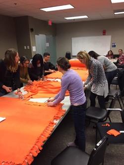 Village of Impact attendees making no-sew blankets